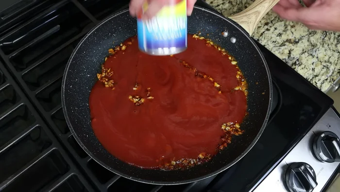 Incorpora la salsa de tomate, el caldo de verduras, sal y pimienta. Ajusta la acidez con azúcar si es necesario.