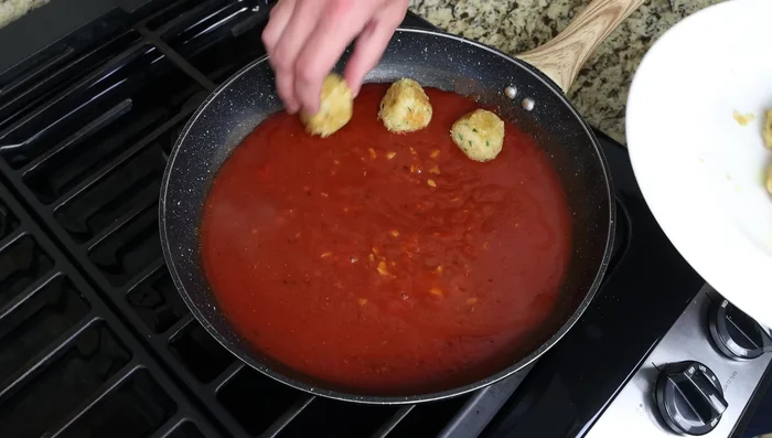 Agrega las albóndigas a la salsa y cocina a fuego lento durante 2-3 minutos, hasta que estén calientes y cubiertas de salsa.