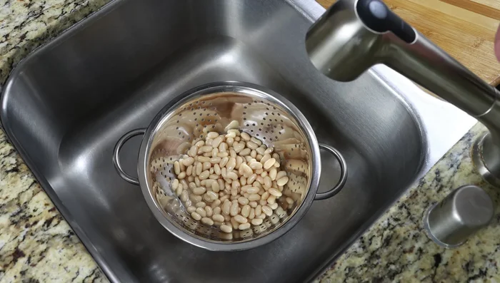 Enjuaga los frijoles blancos en un colador.