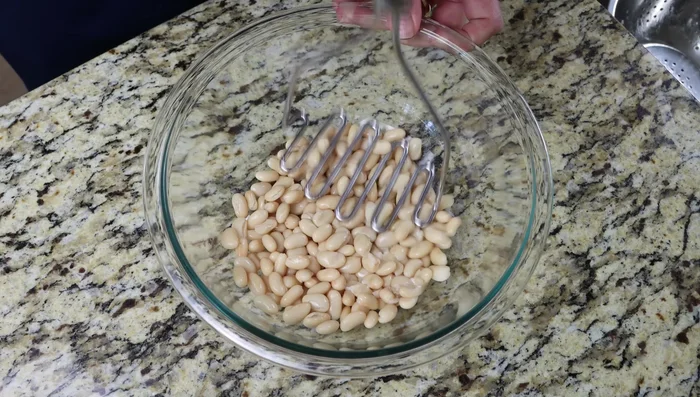 Machaca los frijoles hasta obtener una consistencia pastosa.
