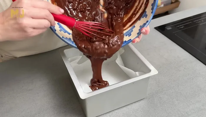 Verter la masa en un molde cuadrado (20x20) forrado con papel de hornear. Repartir uniformemente y añadir los chips de chocolate restantes por encima. (110.399)