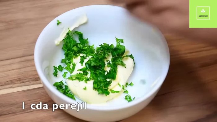 Preparación de la pasta para el pan relleno: Mezcla la mantequilla a temperatura ambiente con el perejil picado, el ajo rallado y el orégano.