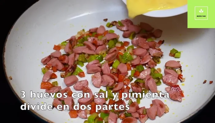 Preparación del desayuno con salchichas y huevos (continuación): En una taza, revuelve los huevos con sal y pimienta. Agrega la mitad de la mezcla de salchichas y verduras a los huevos, cocina y agrega queso mozzarella.