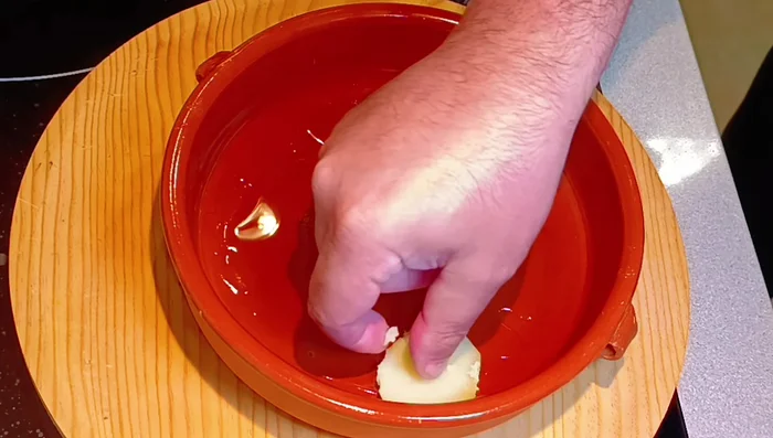 Cortar las patatas cocidas en rodajas y colocarlas en el recipiente de barro.