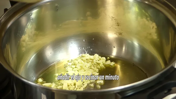 Cubrir con agua o caldo y dejar cocer a fuego medio hasta que las lentejas estén tiernas. (Este paso se infiere de la música de fondo, no hay indicaciones explícitas en el texto.)