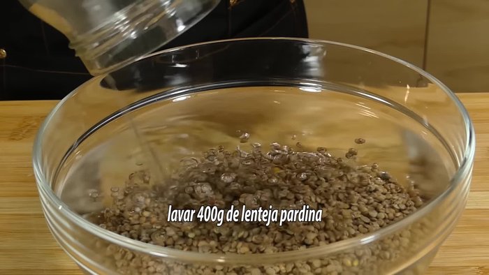 Sofreír la cebolla, el ajo, la zanahoria y el pimiento picados en aceite de oliva. (Este paso se infiere de la música de fondo, no hay indicaciones explícitas en el texto.)