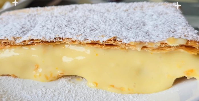 Prepara la crema de naranja: En una cazuela, calienta la leche con el palito de canela, el azúcar y la piel de naranja a fuego medio durante 4 minutos.