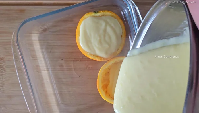 Verter la crema sobre las naranjas.