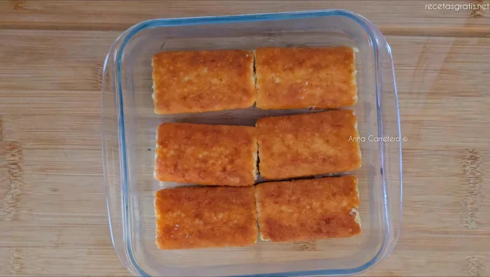 Vierte la crema de naranja sobre los sobaos bañados en leche.