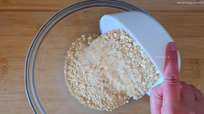Tritura 120g de galletas hasta convertirlas en polvo. Mezcla con 60g de mantequilla derretida.