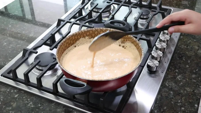 Añadir la salsa de crema a la sartén con el jitomate y dejar hervir.