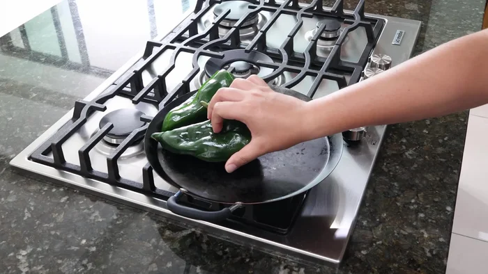 Asar los chiles en un comal a fuego medio durante un par de minutos.