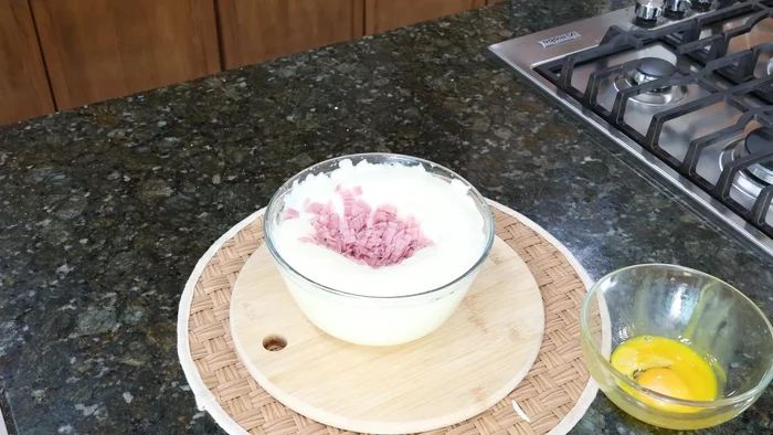 Agregar al huevo batido queso panela y jamón en trocitos pequeños, una pequeña porción de los nopales cocidos y una cucharadita de sal. Mezclar.