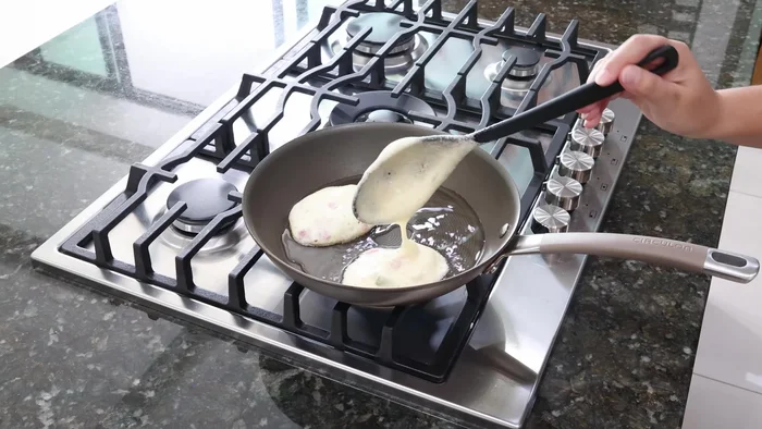 Cocinar pequeñas porciones de la mezcla de huevo en una sartén con aceite caliente hasta que se doren por ambos lados.