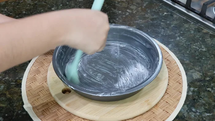 Untar un molde hondo con mantequilla y cubrir la base con las hojas de elote.