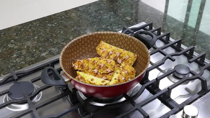 Colocar las cáscaras de piña en una cacerola (47.559). Agregar una taza de arroz limpio (52.48), una rajita de canela (62.879) y dos tazas de agua (65.84).