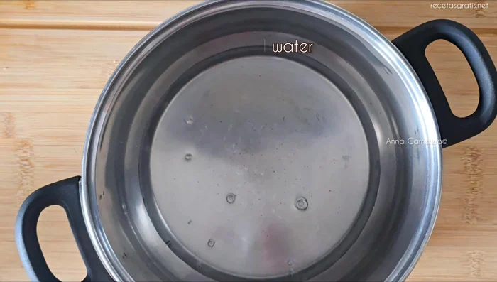 Mientras tanto, preparar el almíbar: en una cazuela, calentar a fuego medio 180 ml de agua, 90 g de azúcar y el zumo de media naranja durante 6 minutos.