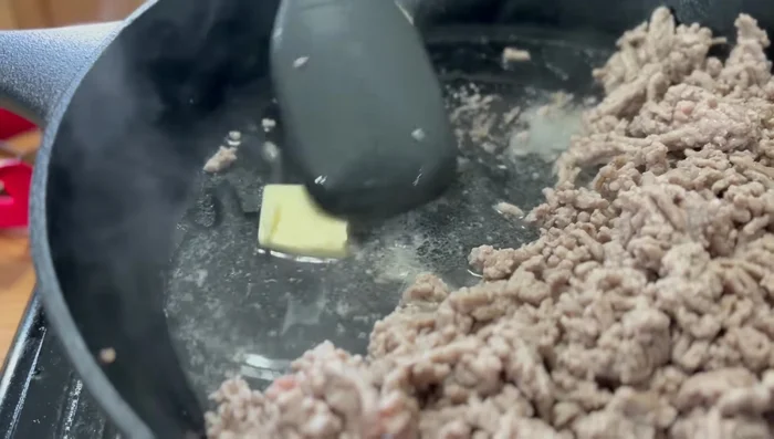 Agregar mantequilla a la sartén, luego añadir la cebolla y el ajo picados. Saltear hasta que estén aromáticos.