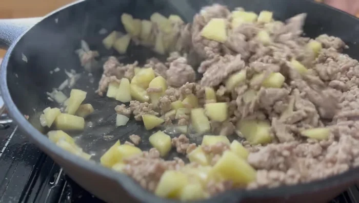 Agregar la carne de cerdo cocida a la sartén con las manzanas. Sazonar con sal, pimienta, salsa Worcestershire y condimento italiano.