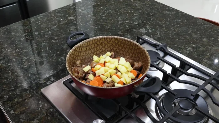 Agrega una zanahoria y una papa picadas a la sartén con las mollejas. Dora las verduras.
