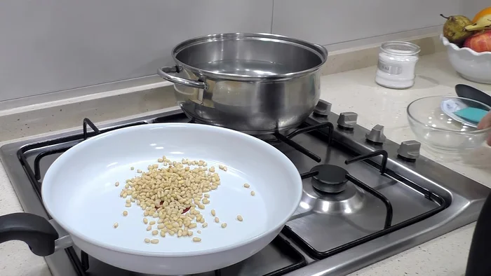 En una sartén sin aceite, dorar los piñones a fuego bajo (se pueden sustituir por nueces o almendras). Reservar y dejar enfriar.
