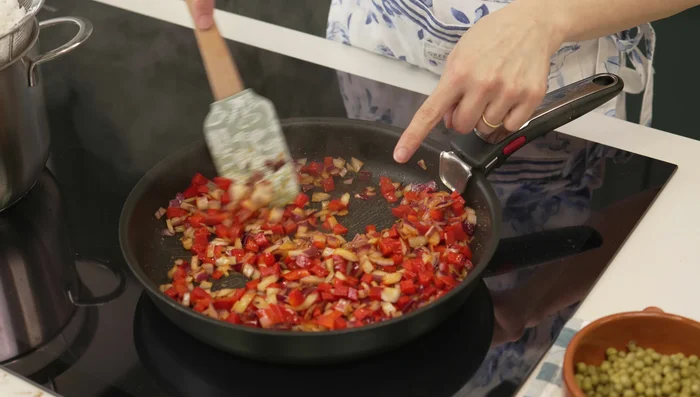 Agregar el arroz a la sartén con el pimiento y la cebolla. Retirar las hojas de laurel. (137.12)
