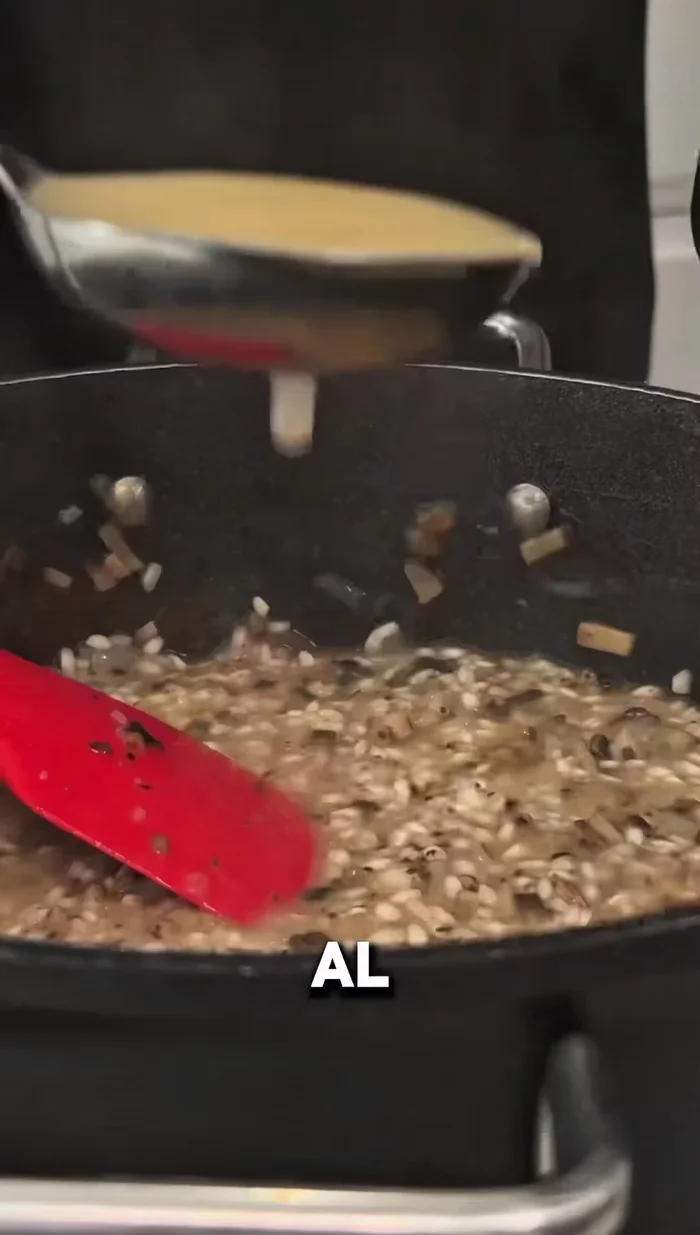 Añadir caldo de pollo al arroz poco a poco, sin dejar de remover, hasta que esté a punto.