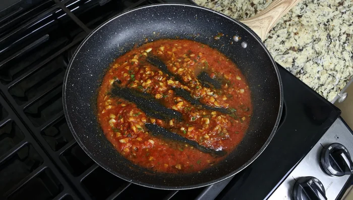 Agregar los fideos fritos a la salsa de tomate. (261.68)