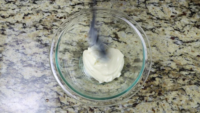 Versión con mayonesa: Mezclar la mayonesa, ajo rallado, jugo de limón, aceite de oliva, sal y pimienta hasta obtener una salsa cremosa. (361.36)