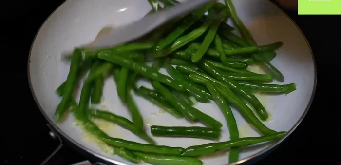 (Opcional) Cocina 2 tazas de ejotes con 1/4 cucharadita de sal, una pizca de pimienta, y 2 cucharadas de agua durante 3 minutos a fuego medio.
