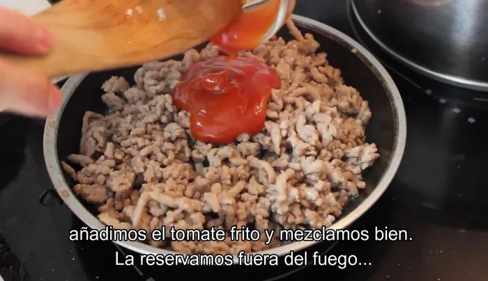 Añadir la salsa de tomate frito a la carne, remover bien y cocinar un minuto más. Retirar del fuego y dejar enfriar.