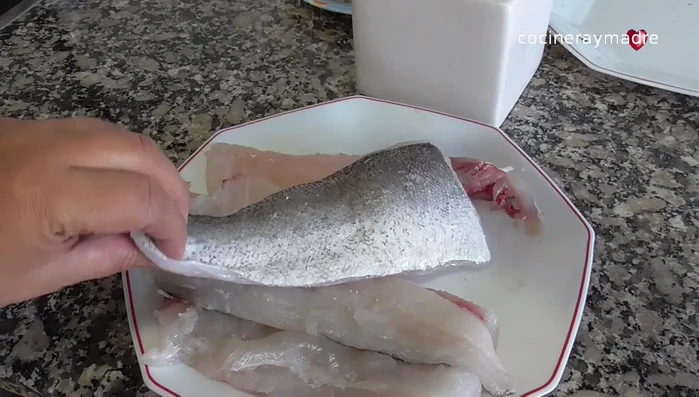 Salpimentar la merluza (fresca o congelada) y pasarla ligeramente por harina. Quitar el exceso de harina.