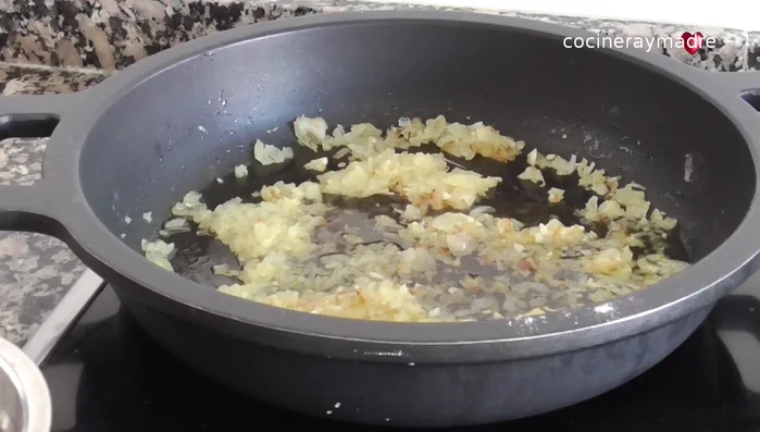 Añadir el resto del vino blanco y dejar reducir. Agregar una cucharada de pimentón dulce y mezclar. Después, añadir el tomate natural triturado y dejar cocinar unos 5 minutos.