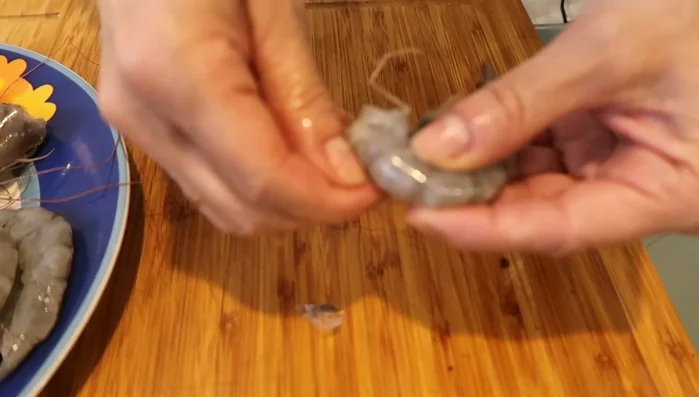 Pelamos los langostinos, reservando las cabezas para la salsa. Quitamos la tripa.