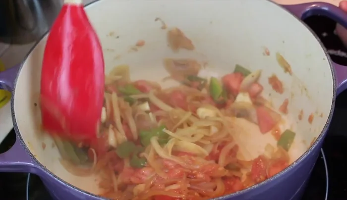 Agregar el tomate y un poco de azúcar al sofrito. Añadir los champiñones y sofreír unos minutos.