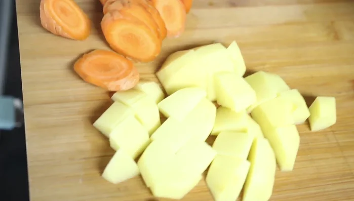 Agregar las papas y zanahorias peladas y cortadas. Mezclar y agregar más salsa de tomate si es necesario.