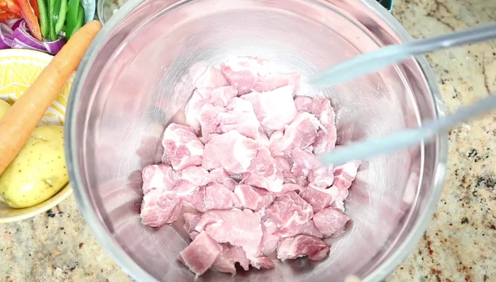Lavar el cerdo con vinagre y jugo de limón, luego enjuagar con agua. Cortar en cubos.