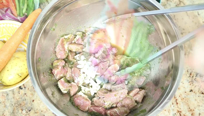 Agregar el ajo picado, cebolla roja, pimientos rojo y verde, culantro y cilantro. Mezclar.