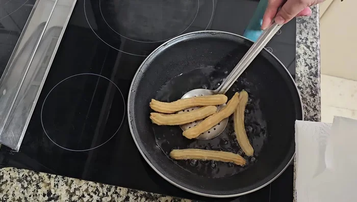 Retirar los churros y colocarlos sobre papel absorbente para eliminar el exceso de aceite. [151.64]
