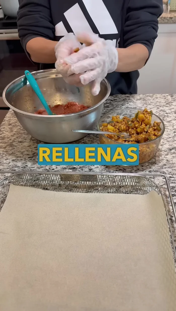 Hacer las bolas de carne: aplastar la carne como una arepa o hamburguesa, añadir el relleno (el guiso) en el medio y cerrar, formando una bola.
