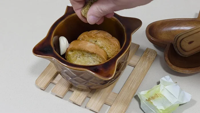 Machacar en un mortero el pan frito, los dientes de ajo, la pastilla de caldo y un poco de sal.