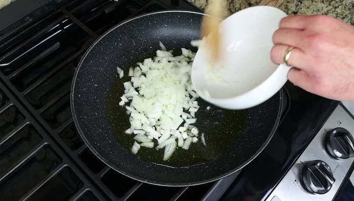 Agregar las verduras picadas a la sartén caliente y mezclar hasta que estén cubiertas de aceite. Cocinar durante 5 minutos, revolviendo constantemente.