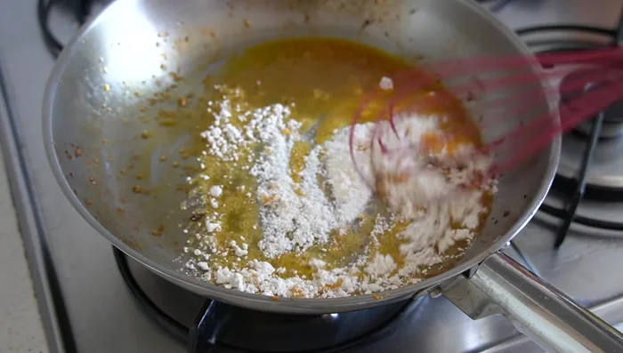 Añadir una cucharada de harina a la sartén y dorarla ligeramente (10-20 segundos) a fuego bajo. [125.24, 138.48]