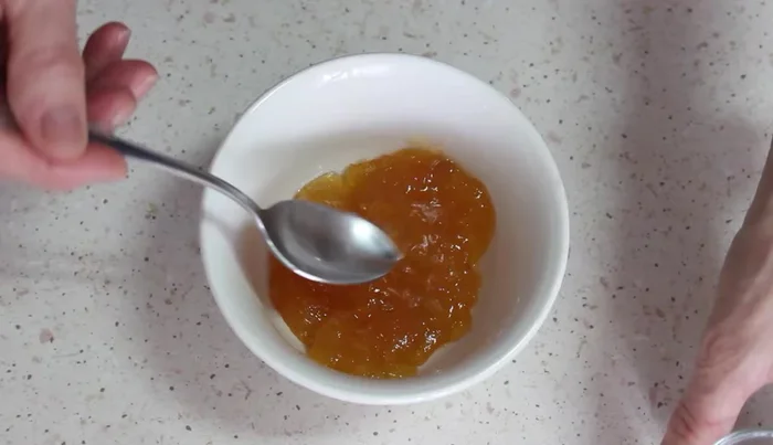 Para el culis, poner la mermelada de melocotón en un cuenco. Añadir una cucharada de zumo de limón y agua. Llevar al microondas o al fuego hasta que se derrita un poco.