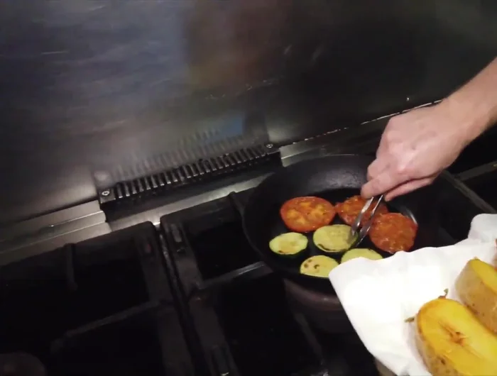 Preparar las guarniciones: patatas asadas y fritas, calabacín y tomate a la plancha (31.68).