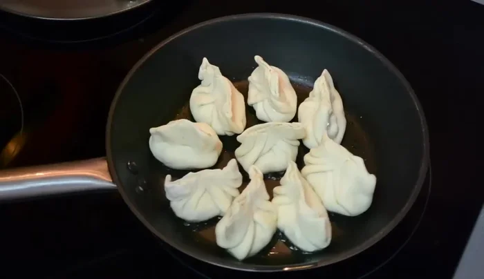 Cocinar las gyozas: Calentamos un poco de aceite en una sartén y cocinamos las gyozas hasta que el agua se evapore (165.879).