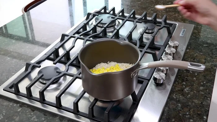 Agregar 1 taza de elote amarillo, sal y 2 tazas de agua. Mezclar e integrar.