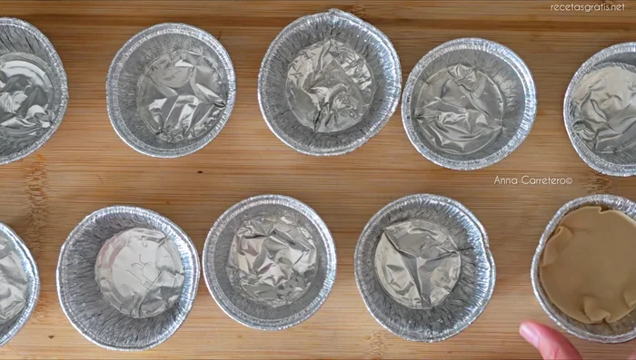 Vierte la crema de leche sobre las obleas en los moldes.