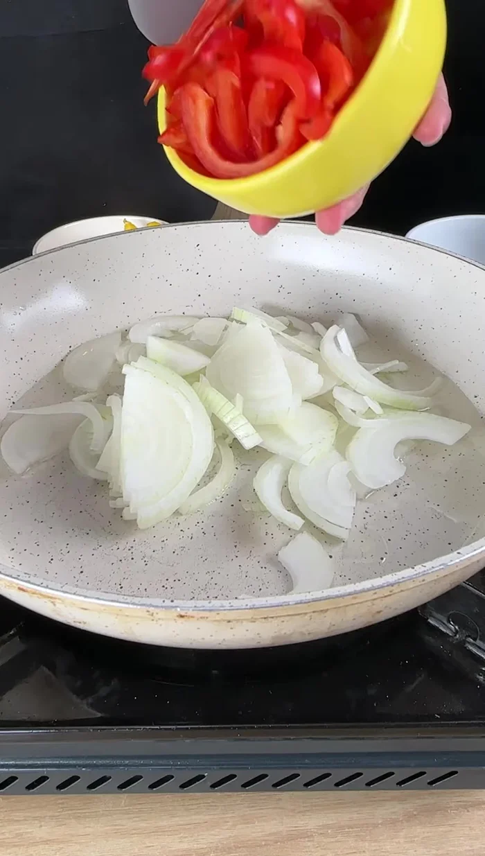 Sofreír la cebolla, el pimiento rojo y amarillo, el ajo y las aceitunas (opcional) en una sartén con aceite.