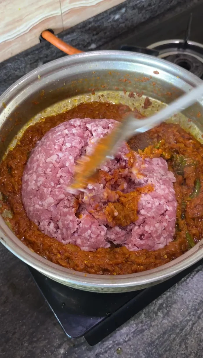 Incorpora el cordero (ka) y mezcla bien con el masala. Agrega una taza de agua y cocina hasta que el agua se evapore y el aceite se separe.